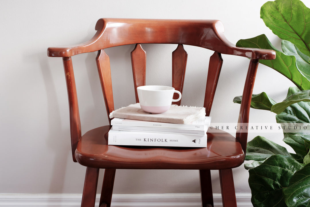 Coffee & books on Brown Chair. Digital Image.