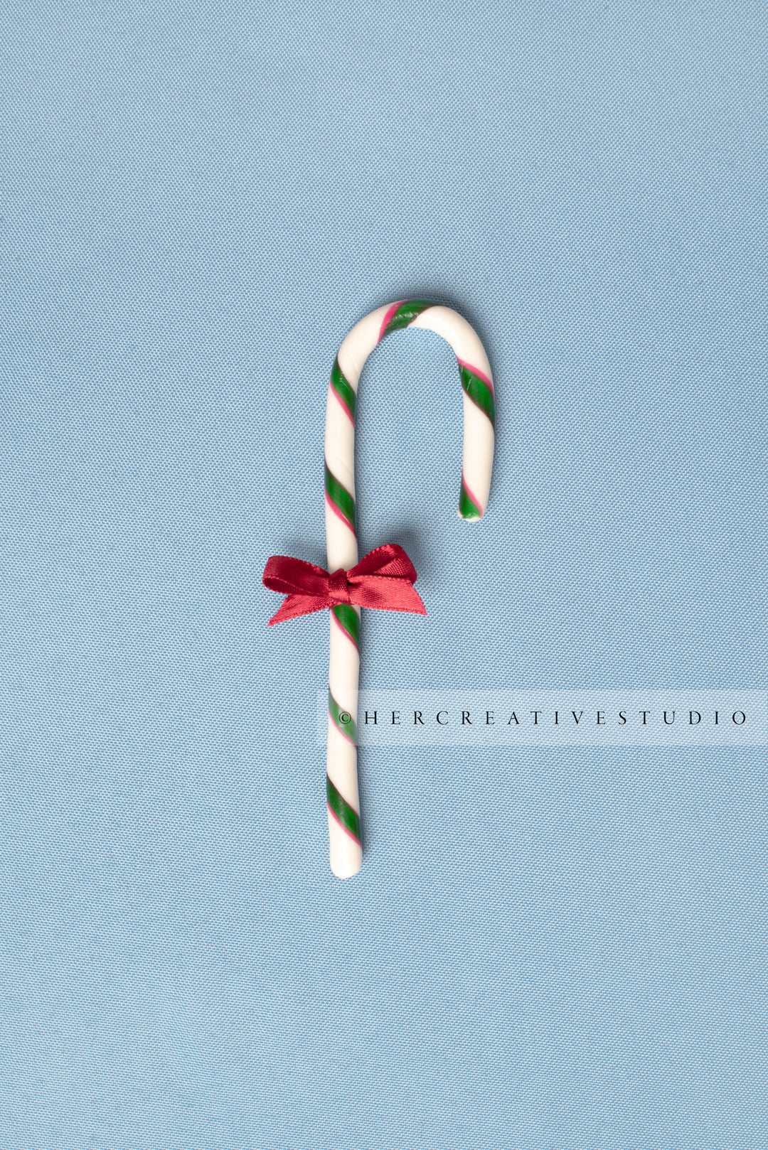 Candy Cane with Red Bow on Sky Blue Background