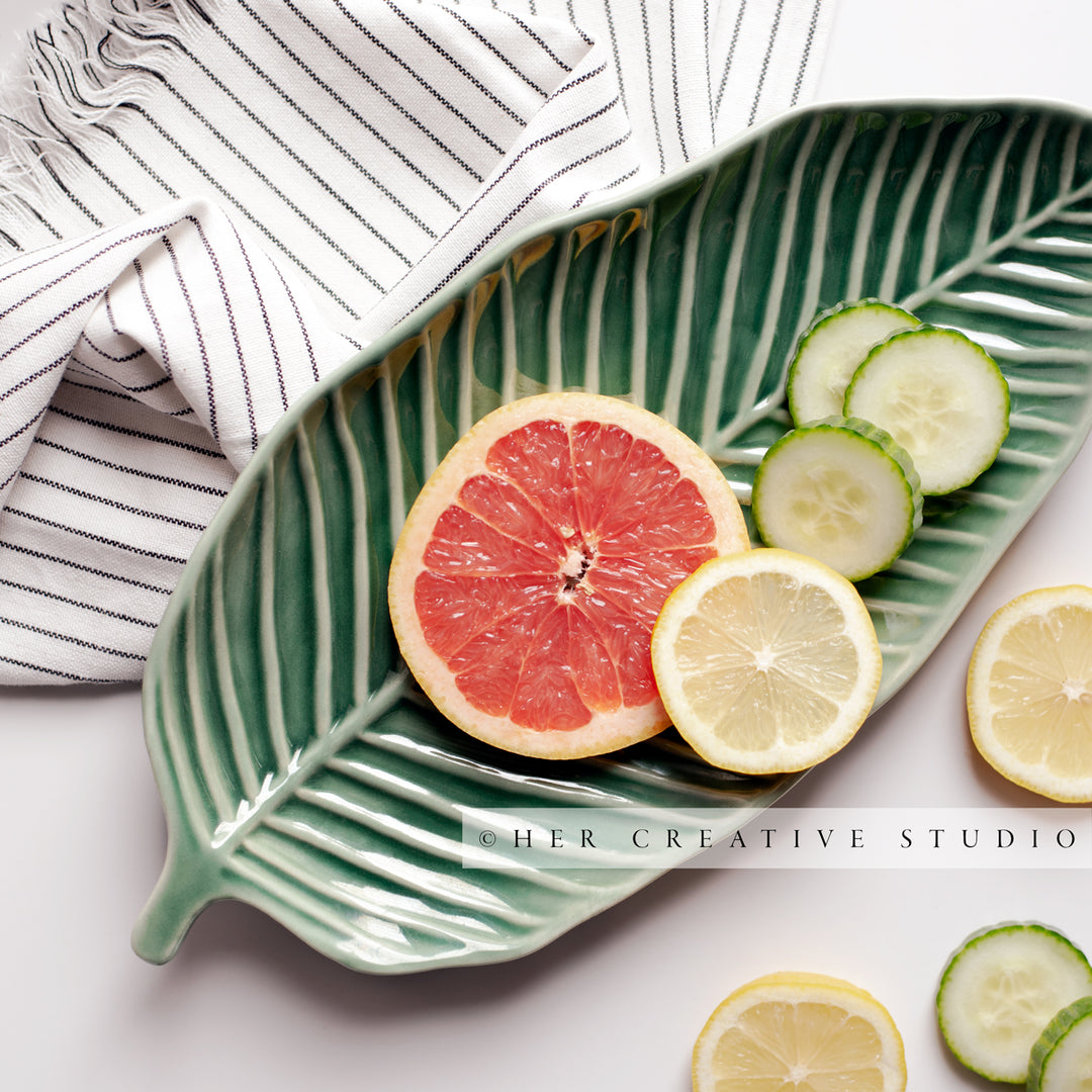Citrus Slices on a Green Leaf Plate. Stock Photo.