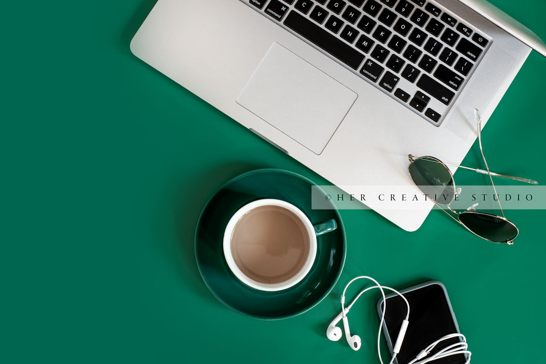 Coffee, Laptop & Sunglasses on Green Background. Digital Stock Image