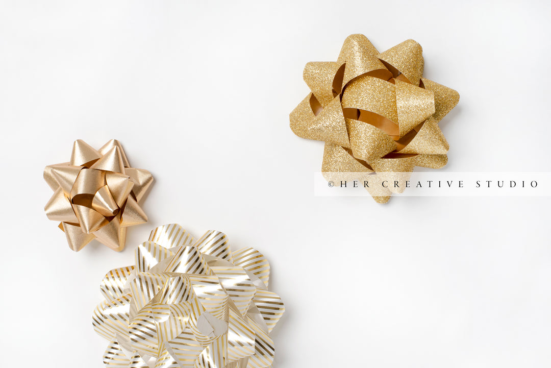 Three Gold Holiday Bows on White Background