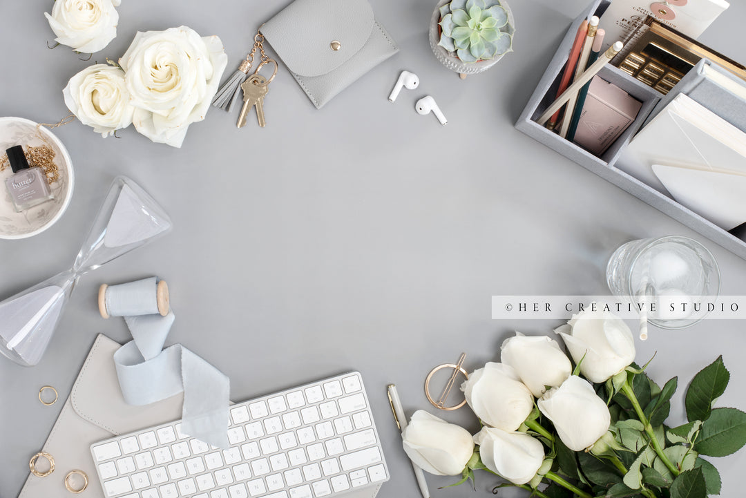 Roses & Desk Accessories on Grey Workspace. Stock Image
