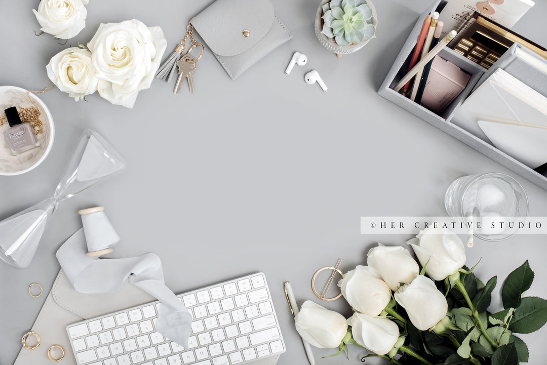 Roses & Hourglass on Grey Workspace. Stock Image