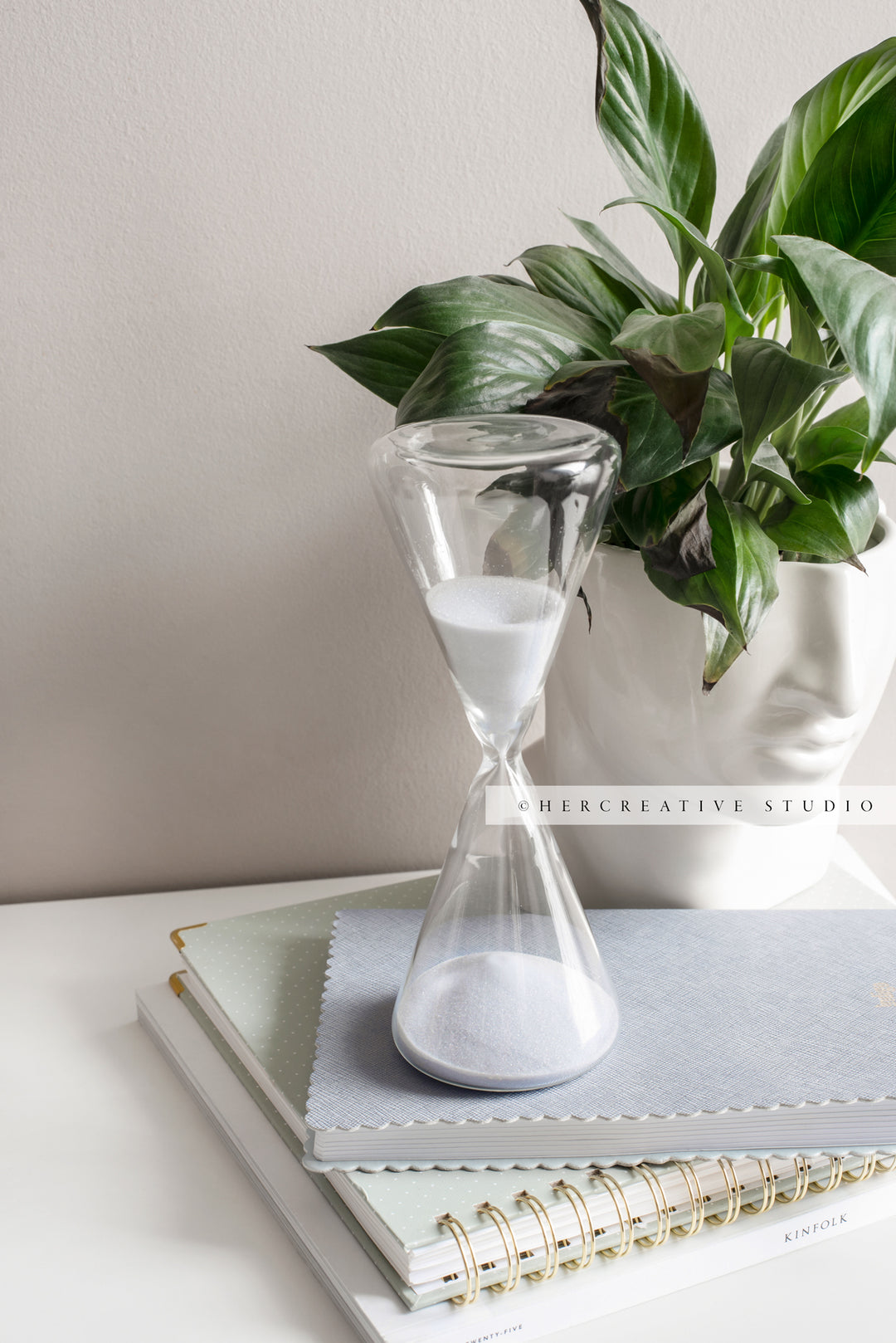 Hourglass, Notebooks and Bust with Greenery. Stock Image