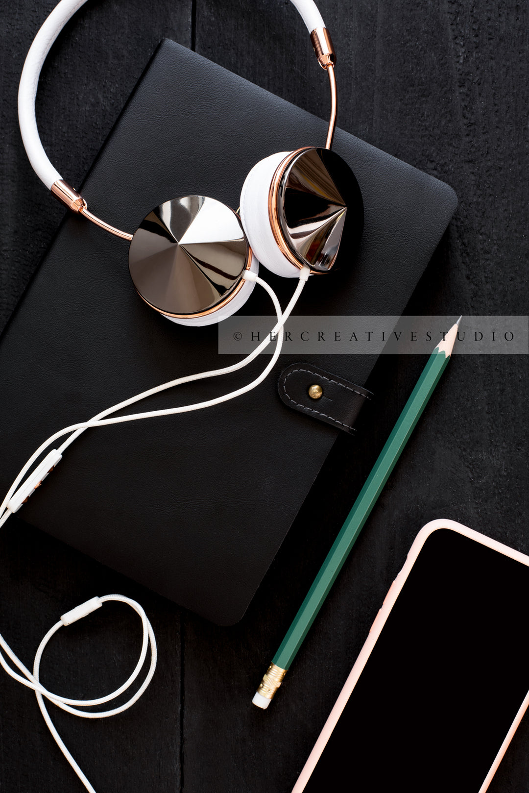 Headphones, Notebook & Pencil on Black Desk