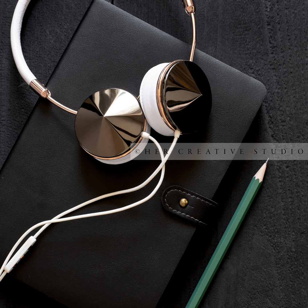 Headphones, Pencil & Notebook on Black Desk
