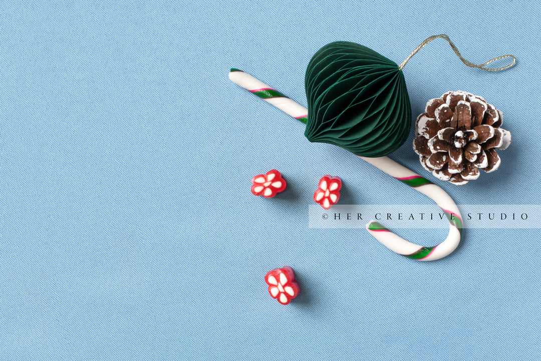 Green Ornament, Pine Cone & Candy Cane on Sky Blue Background