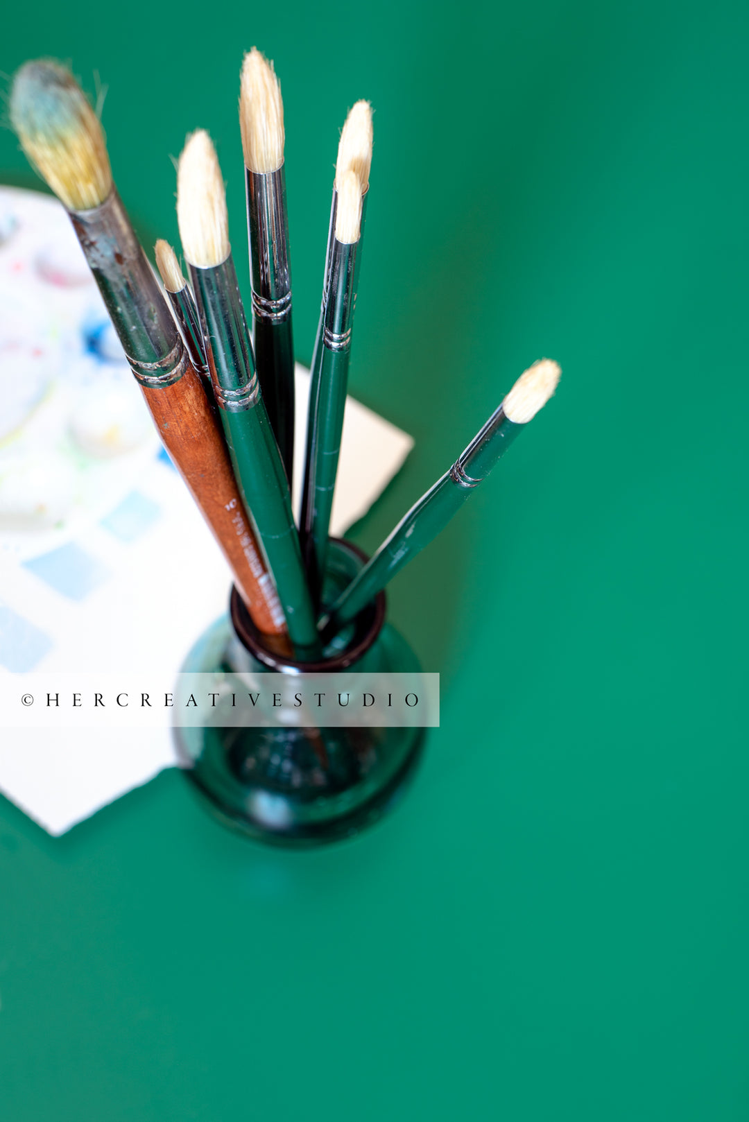 Paintbrushes on Green Background. Styled Stock Image
