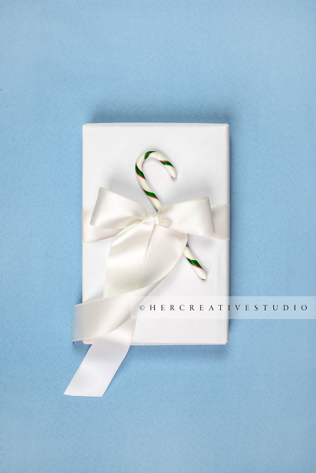Holiday Gift with Candy Cane on Sky Blue Background