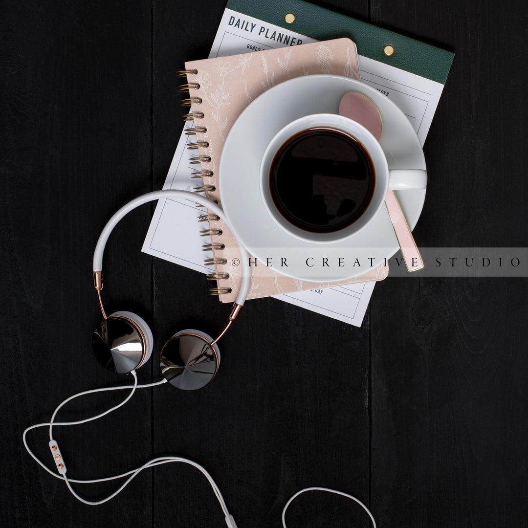 Coffee, Notebooks and Headphones on Black Desk